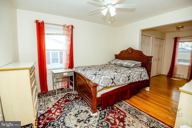 bedroom featuring wood-type flooring, a baseboard radiator, and ceiling fan