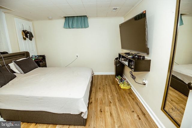 bedroom featuring light hardwood / wood-style flooring and ornamental molding