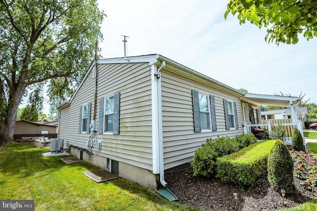 view of home's exterior with central AC and a yard