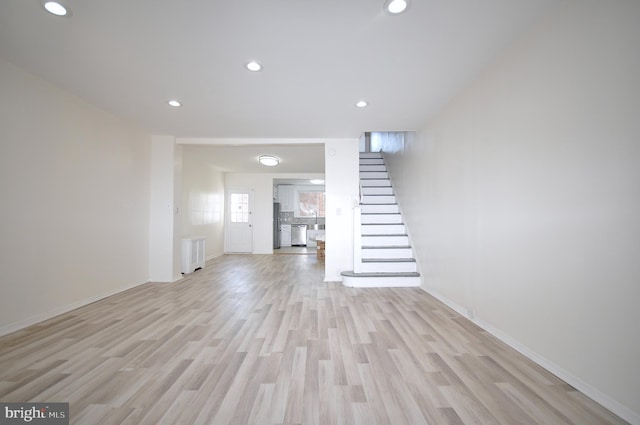 unfurnished living room with light wood-type flooring and radiator