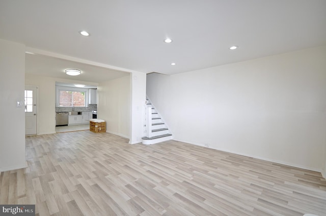 unfurnished living room with sink and light wood-type flooring