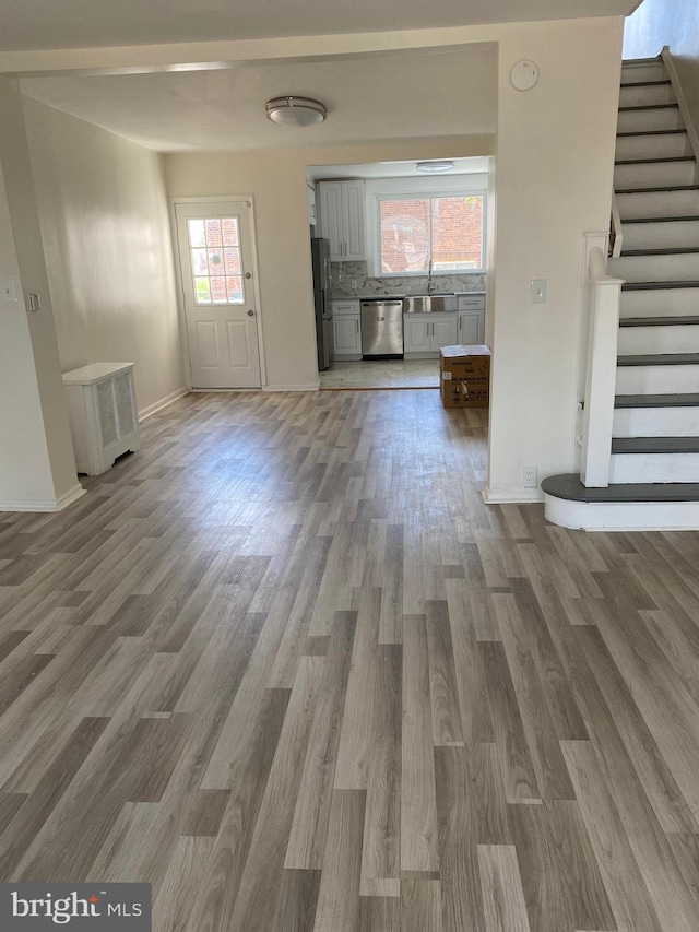 unfurnished living room with plenty of natural light, dark hardwood / wood-style floors, and sink