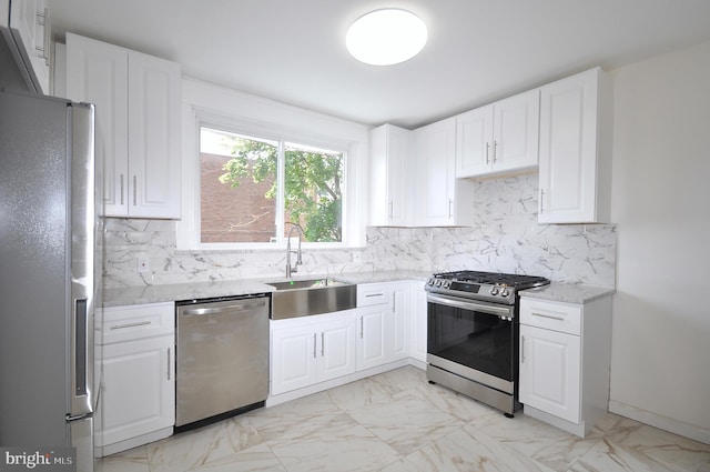 kitchen featuring light stone countertops, white cabinetry, sink, and appliances with stainless steel finishes