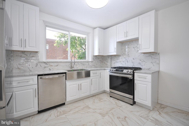 kitchen with light stone countertops, sink, stainless steel appliances, tasteful backsplash, and white cabinets