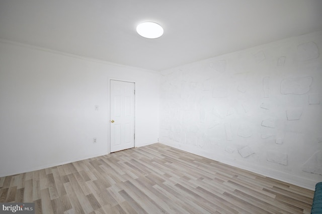 unfurnished room featuring crown molding and light wood-type flooring