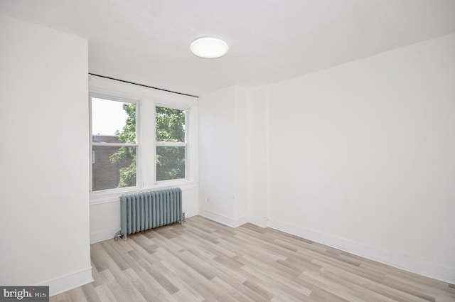 spare room with light hardwood / wood-style floors and radiator