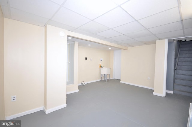 basement featuring a drop ceiling and sink