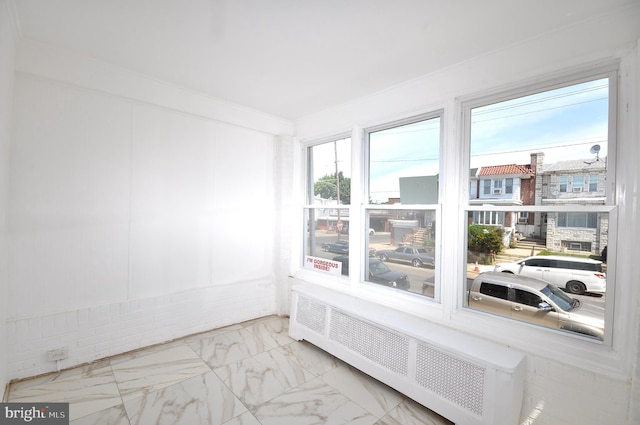 interior space featuring crown molding and radiator heating unit