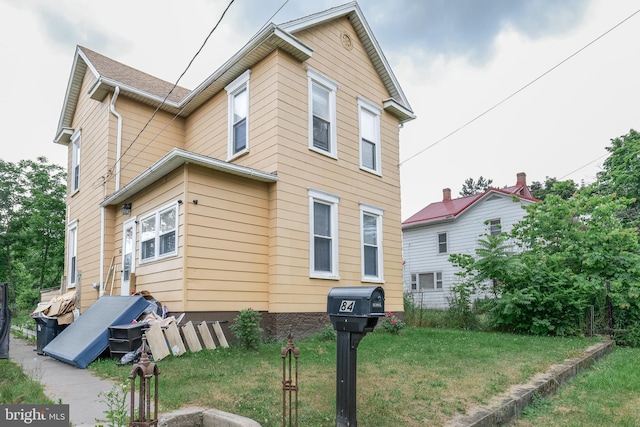 view of side of home with a yard