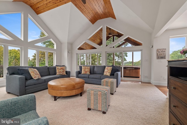 carpeted living room with high vaulted ceiling, plenty of natural light, and wooden ceiling