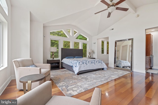 bedroom featuring multiple windows, ceiling fan, ensuite bathroom, and lofted ceiling with beams