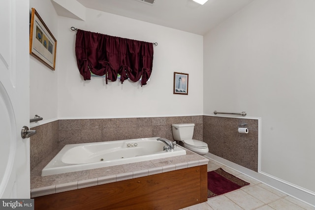 bathroom with tile patterned floors, toilet, and a tub