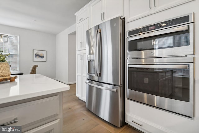 kitchen featuring white cabinetry, light hardwood / wood-style flooring, and appliances with stainless steel finishes