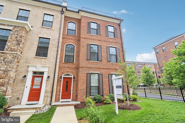 townhome / multi-family property featuring a front lawn