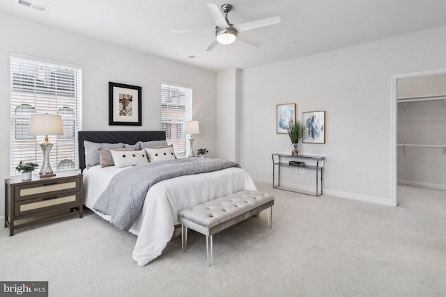 bedroom featuring a closet, light colored carpet, a spacious closet, and ceiling fan