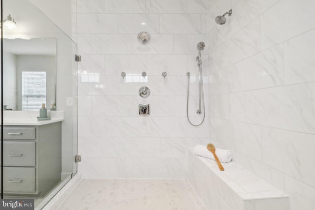 bathroom with a tile shower and vanity