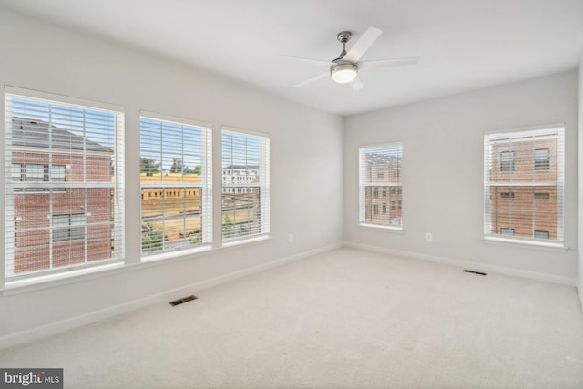 carpeted spare room featuring ceiling fan