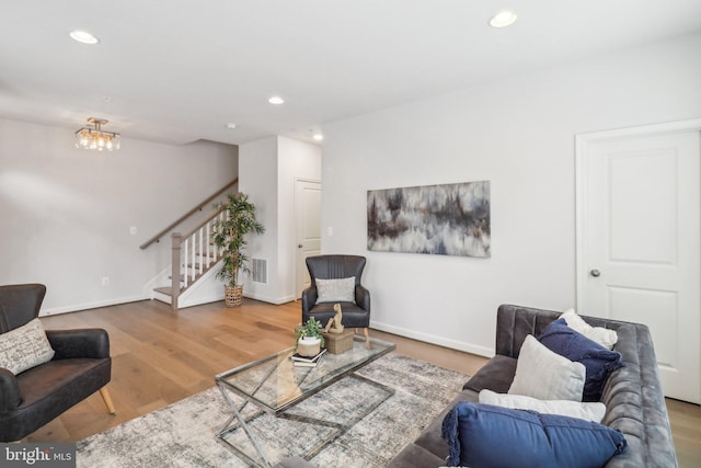 living room featuring wood-type flooring and an inviting chandelier