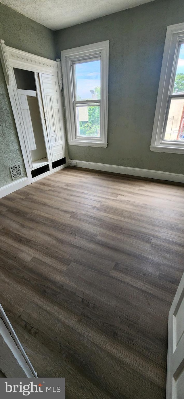 unfurnished bedroom with a textured ceiling and hardwood / wood-style flooring