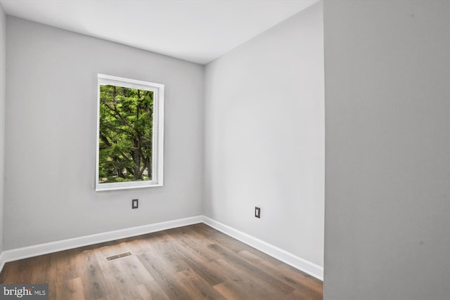 empty room with dark hardwood / wood-style flooring