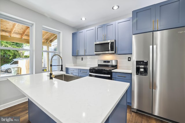 kitchen with a center island with sink, dark hardwood / wood-style flooring, sink, and stainless steel appliances