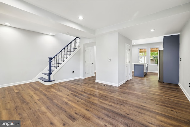 unfurnished living room featuring sink and dark hardwood / wood-style floors