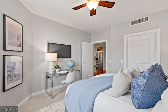 bedroom with ceiling fan, light colored carpet, and stainless steel fridge with ice dispenser