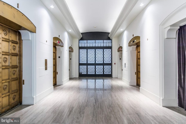 interior space with lofted ceiling, brick ceiling, and hardwood / wood-style flooring