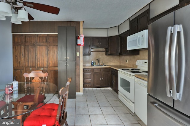 kitchen featuring a ceiling fan, a sink, white appliances, light countertops, and light tile patterned floors