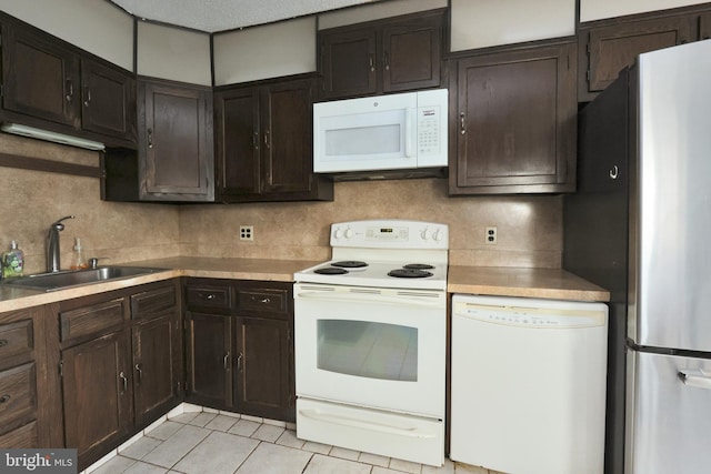 kitchen featuring white appliances, light tile patterned floors, tasteful backsplash, and a sink