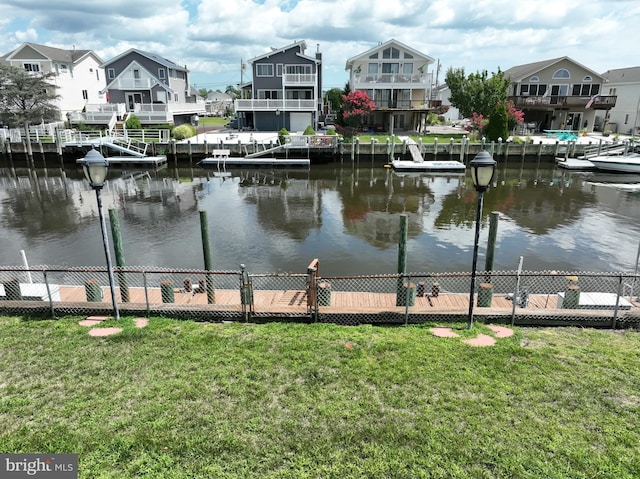 property view of water with a residential view, a boat dock, and fence