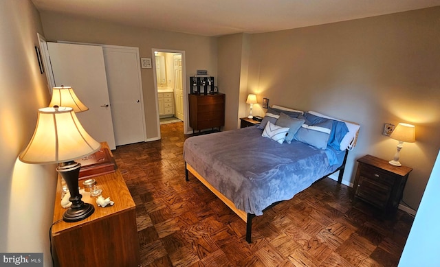 bedroom featuring dark parquet flooring and connected bathroom