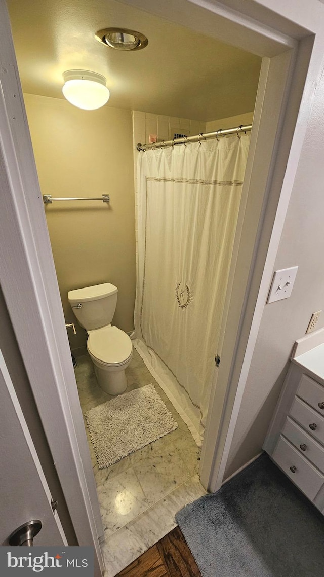 bathroom with toilet and curtained shower