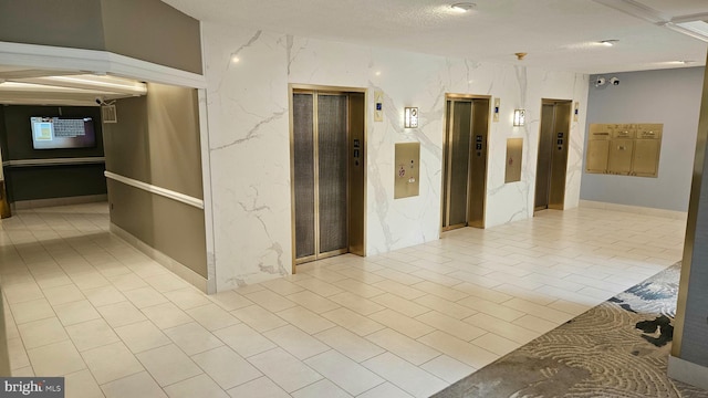 corridor with a textured ceiling and elevator