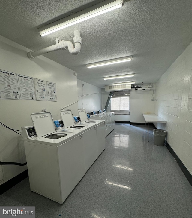 laundry room featuring washer and dryer and a textured ceiling