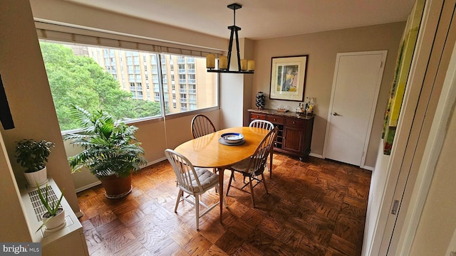 dining area with dark parquet flooring and a notable chandelier