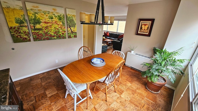 dining space with a notable chandelier and parquet flooring