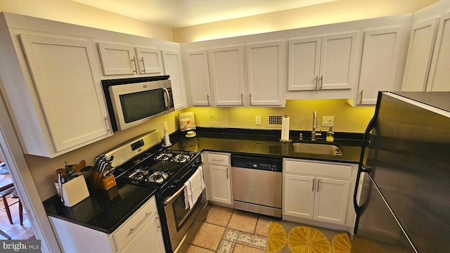 kitchen featuring white cabinets, sink, light tile patterned floors, and stainless steel appliances