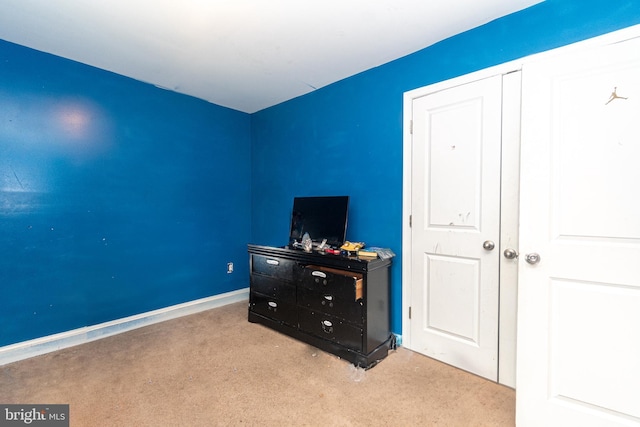 unfurnished bedroom with a closet and light colored carpet