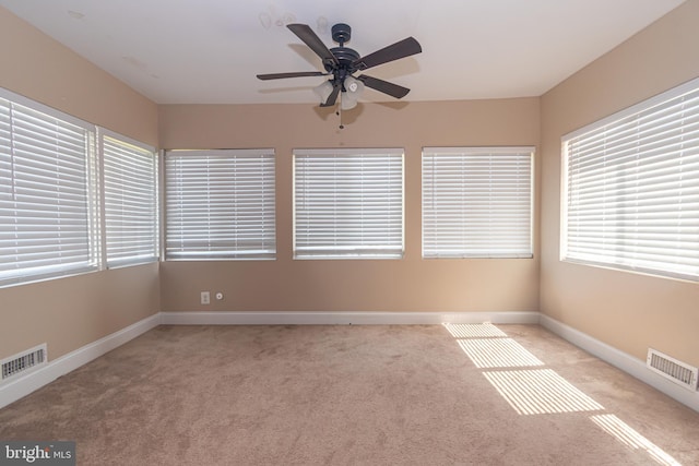 unfurnished sunroom featuring ceiling fan