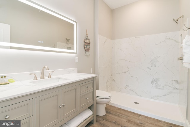 bathroom with walk in shower, vanity, wood-type flooring, and toilet