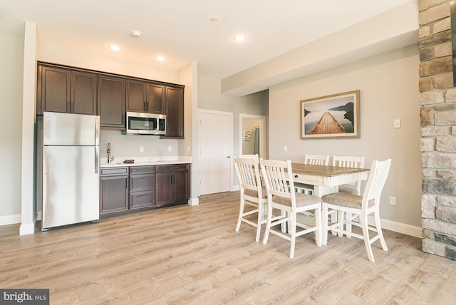 kitchen featuring light hardwood / wood-style floors, dark brown cabinetry, and stainless steel appliances