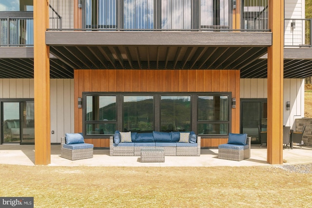 back of house featuring a patio area, an outdoor living space, and a balcony