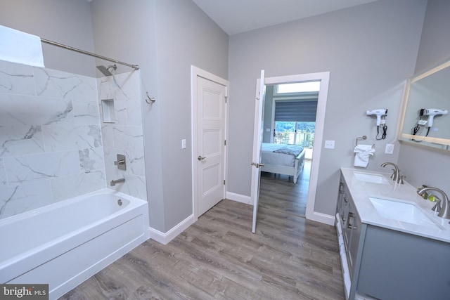 bathroom with hardwood / wood-style flooring, vanity, and  shower combination