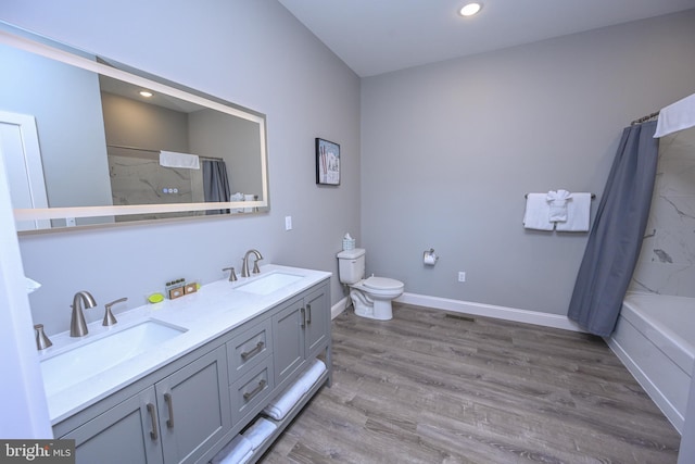 full bathroom featuring wood-type flooring, vanity, toilet, and shower / tub combo with curtain