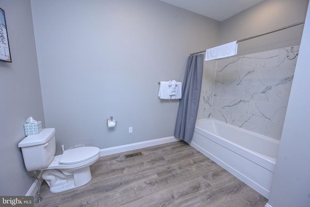 bathroom with hardwood / wood-style flooring, toilet, and shower / tub combo with curtain