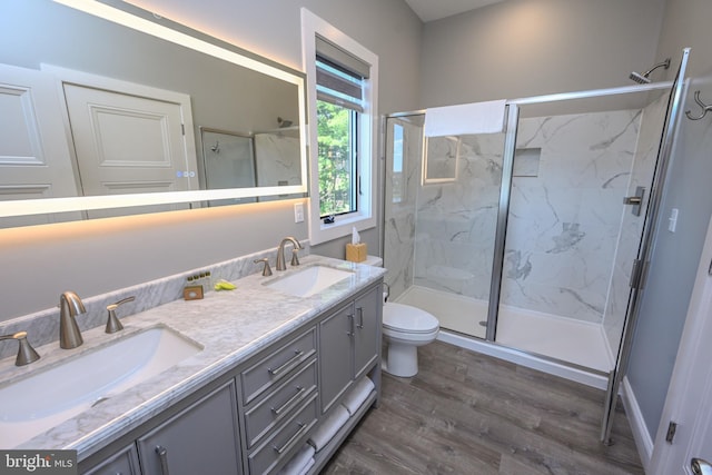 bathroom with hardwood / wood-style floors, vanity, toilet, and an enclosed shower