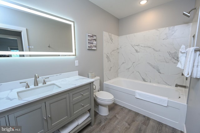 full bathroom with vanity, toilet, washtub / shower combination, and hardwood / wood-style flooring