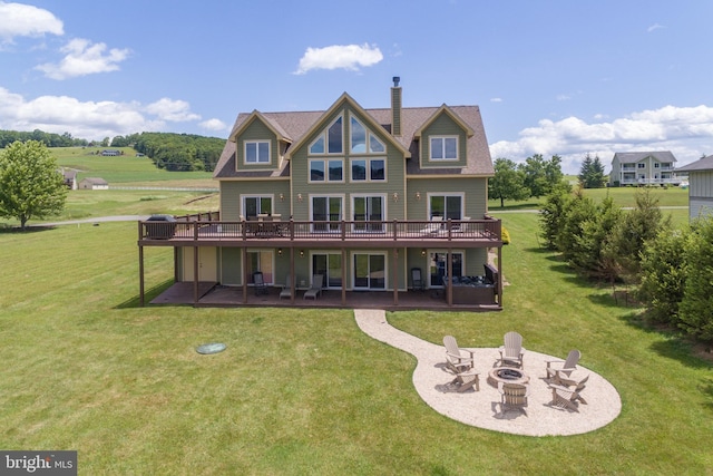 back of property featuring a yard, a patio, a deck, and an outdoor fire pit