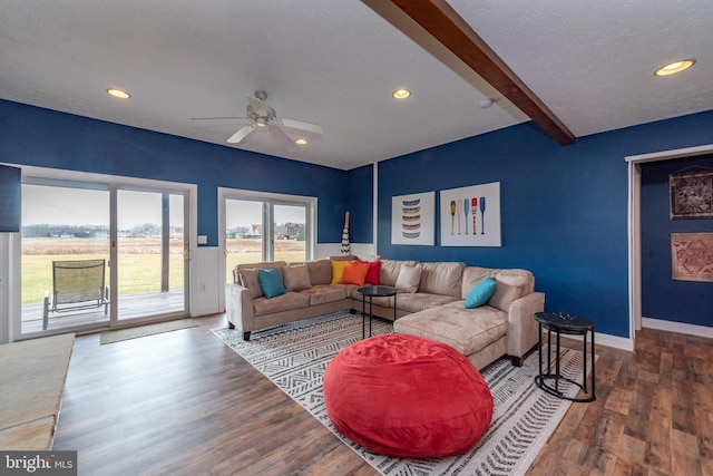 living room with ceiling fan, beam ceiling, and wood-type flooring